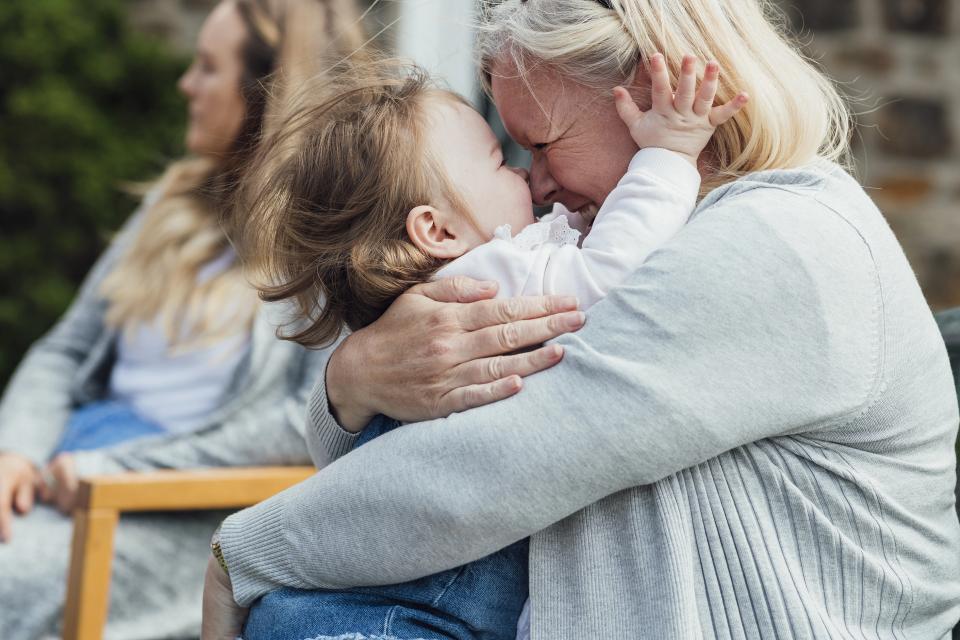 Barnebarn og bedstemor omfavner hinanden