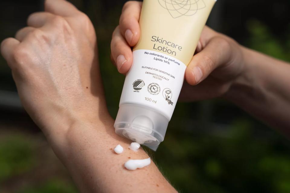 Person, der lægger skincare lotion på håndled