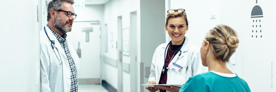 Tre personer fra sundhedssektoren som taler sammen.